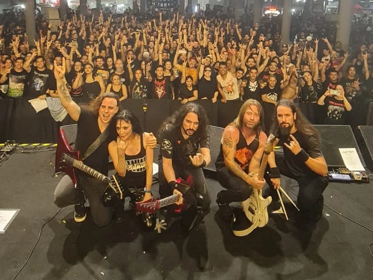 Leather Leone, Fabio Carito and the band posing on stage in front of the crowd after the show